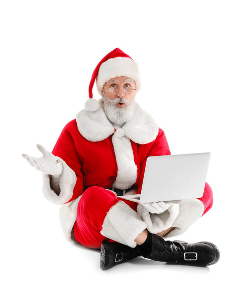 Sorprendido Santa Claus con portátil sobre fondo blanco - Foto, Imagen