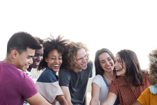 Farklı ırktan insanların el ele tutuşup birbirlerine baktıkları uzay portresini kopyala. Bir grup insan eğleniyor ve kutluyor. Renkli. - Fotoğraf, Görsel