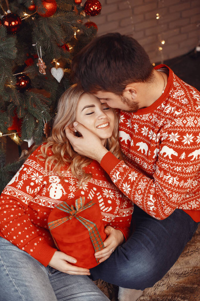 Cute couple sitting at home near christmas tree - Foto, Imagem