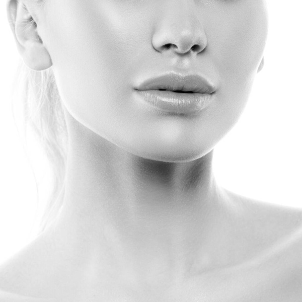 Retrato de modelo femenino hermoso con cara limpia aislada sobre fondo blanco. Mujer joven muestra una piel sana y sensible después de la cirugía plástica cosmetología inyección de relleno de botox - Foto, imagen