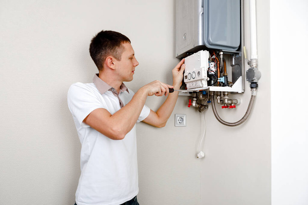 Plumber attaches Trying To Fix the Problem with the Residential Heating Equipment. Repair of a gas boiler - Fotoğraf, Görsel