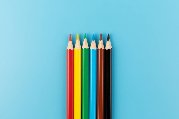 Composition with colored pencils on a bright blue background. top view. space for text.frame - Foto, imagen