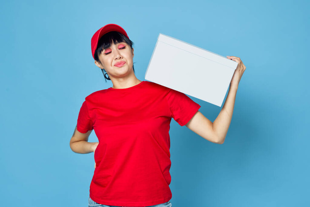 woman with box in hands delivery courier blue background - Valokuva, kuva