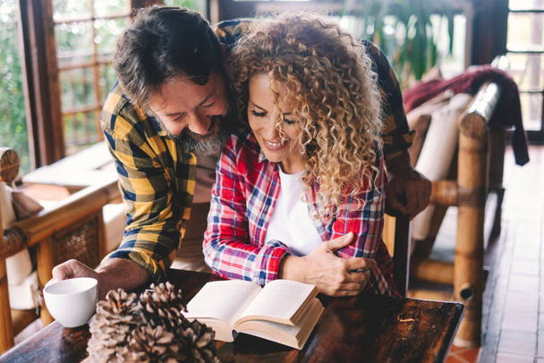Glückliche Beziehung Paar von Erwachsenen zu Hause ein Buch lesen und genießen Sie die gemeinsame Zeit.  - Foto, Bild