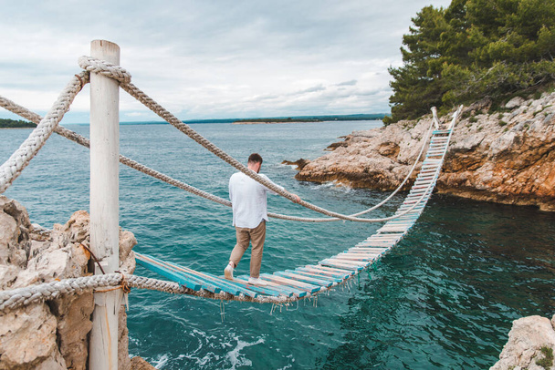 человек ходит по подвесному мосту летнее время копировальное пространство - Фото, изображение