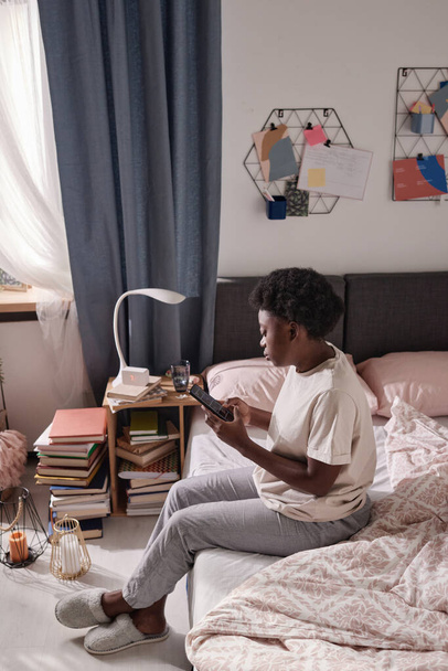 Mujer usando teléfono móvil en el dormitorio - Foto, Imagen