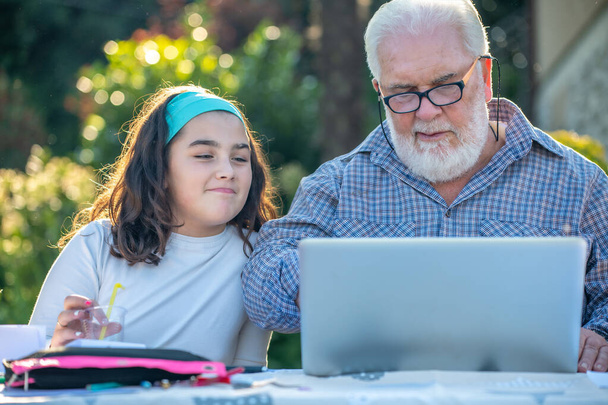 Abuelo explica cómo utilizar el ordenador portátil a su nieta - Foto, Imagen