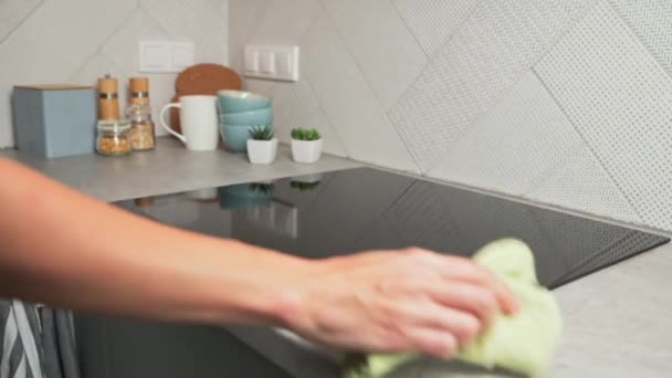 Mulher em luvas de borracha limpeza fogão de indução - Filmagem, Vídeo