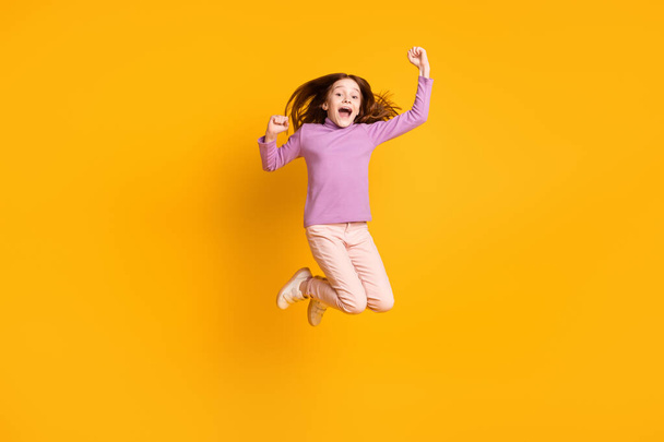 Full length body size view of attractive cheerful girl jumping rejoicing great success isolated over bright yellow color background - Foto, Imagen