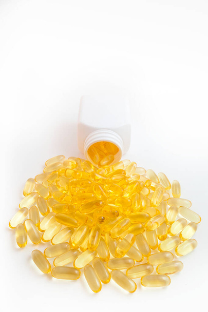 omega 3 tabletta ömlött ki az üvegből, fehér alapon - Fotó, kép