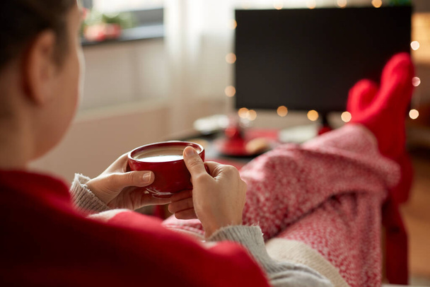 woman watching tv and drinking coffee on christmas - Fotoğraf, Görsel