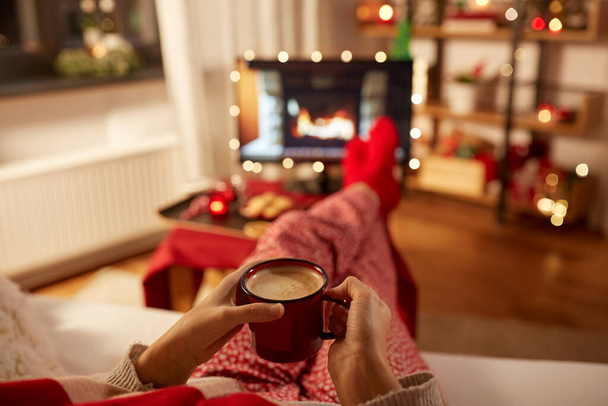woman watching tv and drinking coffee on christmas - Photo, image