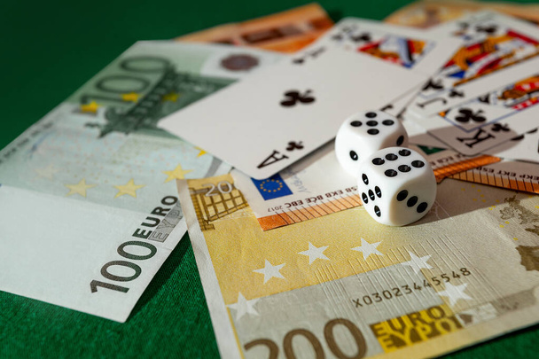 Кишинев, Молдова - 20. 412. Кости 2020 года, игральные карты на зеленой тканью в долларах казино и евро счетов  - Фото, изображение