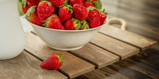 frisch gepflückte Bio-Erdbeere und Milch auf Holztisch natürlicher Hintergrund, Landschaft, gesunde Ernährung - Foto, Bild
