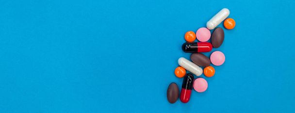 multicolored pills texture on blue panorama background - Foto, Bild