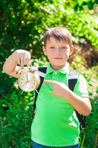 Boy with a backpack and a clock in hands - Foto, Imagen