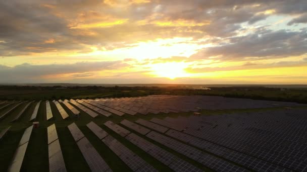 Letecký pohled na velkou udržitelnou elektrárnu s řadami solárních fotovoltaických panelů pro výrobu čisté ekologické elektrické energie při západu slunce. Obnovitelná elektřina s koncepcí nulových emisí - Záběry, video