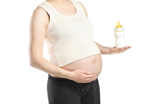Pregnant woman holding bottle of milk - Фото, зображення