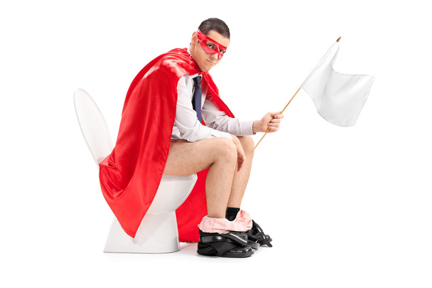 Superhero holding white flag seated on toilet - 写真・画像
