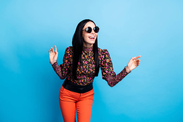 Photo of attractive positive young woman wear sunglass look empty space isolated on blue color background. - Fotó, kép