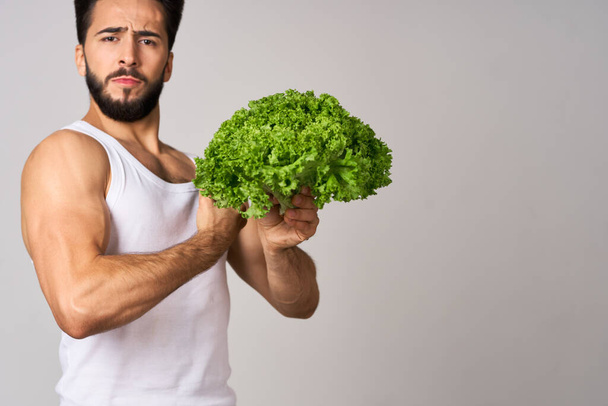 uomo barbuto in bianco t-shirt lattuga foglia verdura cibo sano - Foto, immagini