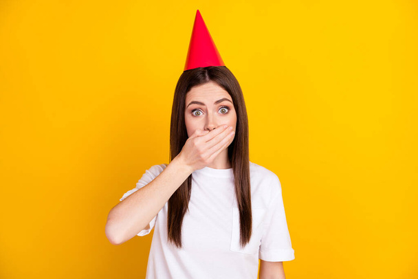 Photo of shocked amazed surprised woman in cone hat cover close mouth sorry guilty isolated on yellow color background. - Photo, Image