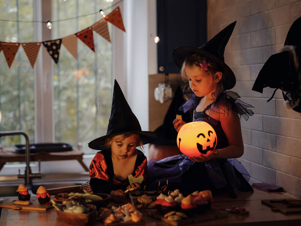 ハロウィーンの休日と子供時代のコンセプト。休日の暗い家の魔女の衣装で幸せな子供ハロウィン,ジャックoランタン - 写真・画像