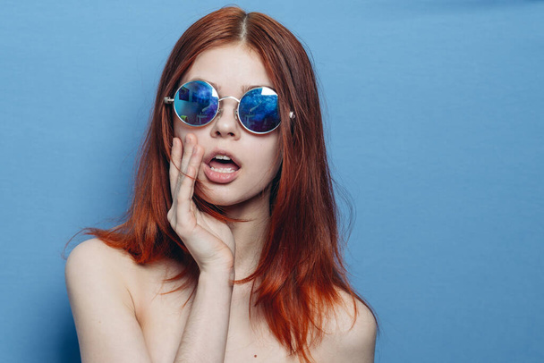 perky red-haired woman in blue glasses bare shoulders posing - Фото, зображення