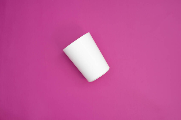 una singola coppa bianca isolata su fondo rosa. utensile girato dal punto di vista superiore. piatti usa e getta per grafica e uso mockup. - Foto, immagini