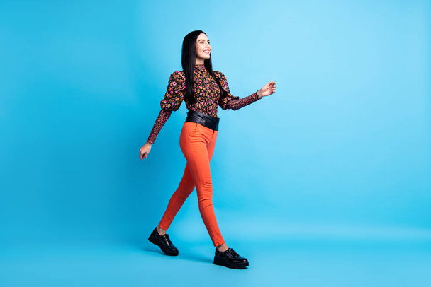 Photo of charming lady walk wear floral print shirt trousers footwear isolated blue color background - Foto, Imagem