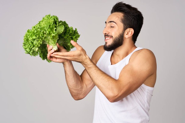 Cheerful man lettuce leaves healthy food posing - Фото, изображение