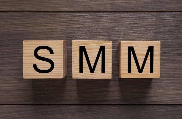 Cubes with abbreviation SMM (Social media marketing) on wooden table - Фото, зображення