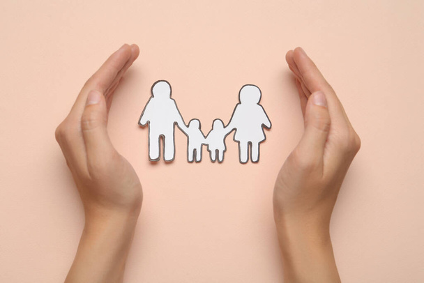 Woman with paper family cutout on beige background, top view - Foto, Bild