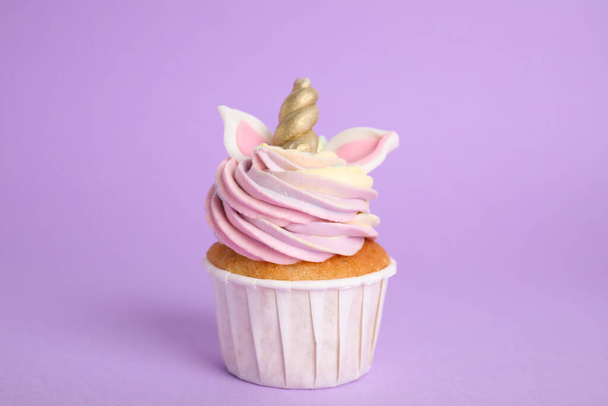 Cute sweet unicorn cupcake on violet background - Foto, afbeelding
