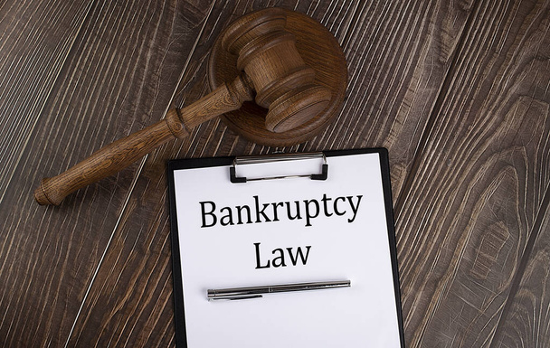 Текст закону про банкрутство на папері з даниною на дерев'яному тлі
 - Фото, зображення