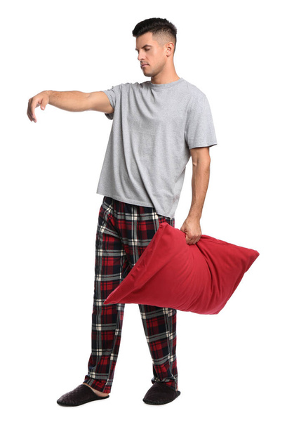 Somnambulist with red pillow on white background. Sleepwalking - Фото, зображення