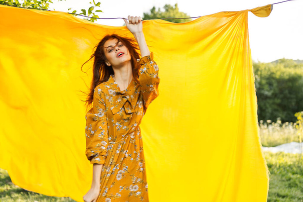 smiling woman in yellow dress posing nature yellow cloth - Zdjęcie, obraz