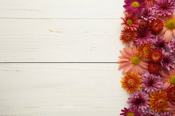 Pink flowers on white wooden background. Flower composition. - 写真・画像