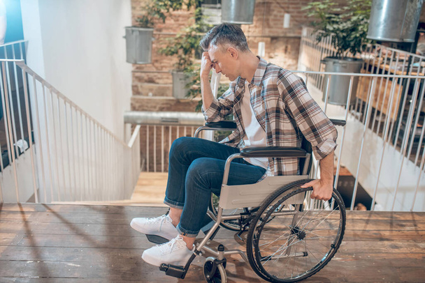 Muž na invalidním vozíku medituje u schodů - Fotografie, Obrázek