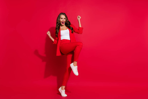 Full body photo of cool impressed brunette lady wear suit sneakers isolated on red color background. - 写真・画像