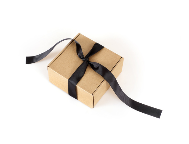 Una scatola artigianale con fiocco nero e nastro isolato su uno sfondo bianco - Foto, immagini