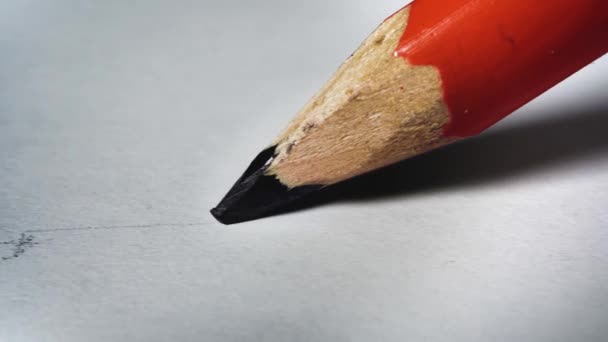 Potlood tekent een zwarte lijn op wit papier close-up - Video