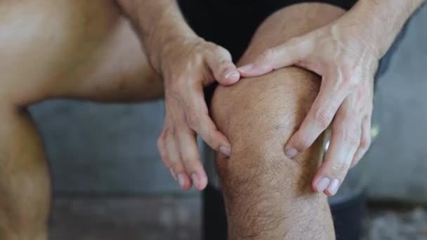 close up man massages zijn knie van pijn - Video