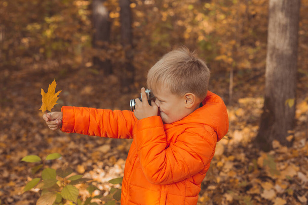 Fiú retro fényképezőgép fotózás szabadban ősszel természet. Szabadidő és fotósok koncepciója - Fotó, kép