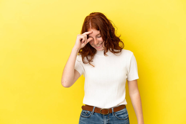 Teenager reddish woman isolated on yellow background laughing - Photo, Image