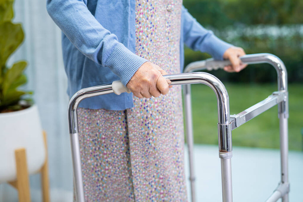 アジアの高齢女性高齢者の女性患者は、看護病院病棟で歩行者と歩く,健康的な強力な医療の概念 - 写真・画像