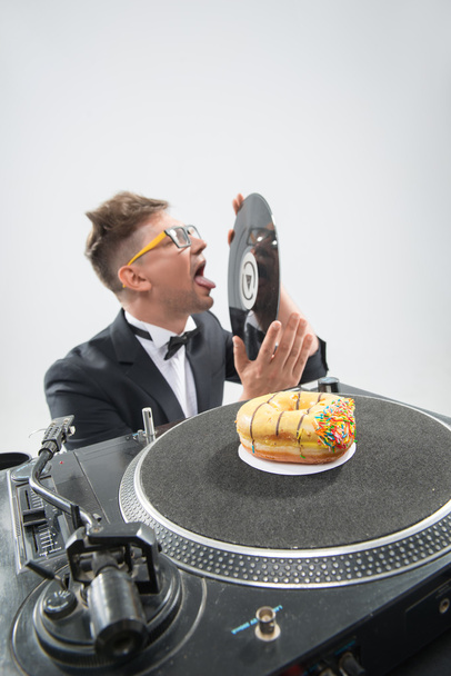 DJ donut eten op werkende plaats draaitafel - Foto, afbeelding