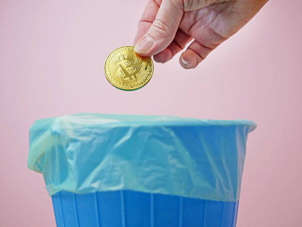 mano tirando fuori bitcoin in contenitore della spazzatura, Concetto di riciclaggio della spazzatura globale e recessione, inflazione - Foto, immagini