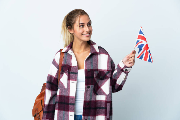 Junge Frau mit einer britischen Flagge auf weißem Hintergrund, die eine Idee denkt, während sie nach oben schaut - Foto, Bild
