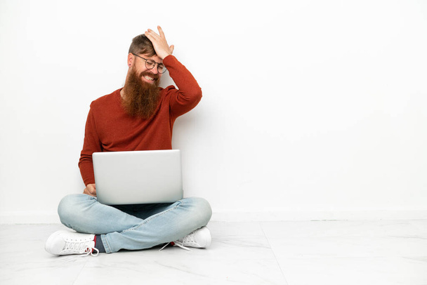 Jovem homem caucasiano avermelhado com laptop isolado em fundo branco percebeu algo e pretendendo a solução - Foto, Imagem